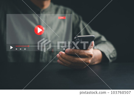 Witness the magic of online movie streaming on a smartphone as a young man explores the virtual world of film. Embrace the seamless integration of technology, entertainment, and imagination. Witness the magic of online movie streaming on a smartphone as a young man explores the virtual world of film. Embrace the seamless integration of technology, entertainment, and imagination. 103768507