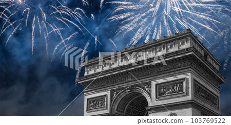 Celebratory colorful fireworks over the Arc de Triomphe, Paris, France. The walls of the arch are engraved with the names of 128 battles and names of 660 French military leaders (in French) 103769522