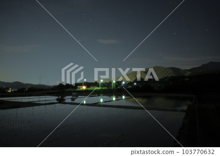 北斗市竹川町舞鶴橋上閃耀著紅色光芒的心宿二和倒映著星空的稻田 103770632