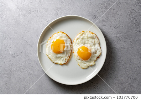 Fried eggs in a plate, food breakfast, healthy proteins. 103770700