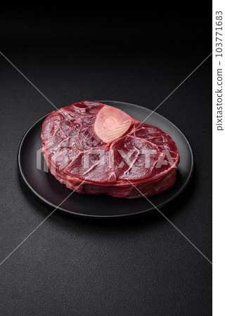 Fresh beef ossobuco steak with salt, spices and herbs Fresh beef ossobuco steak with salt, spices and herbs 103771683