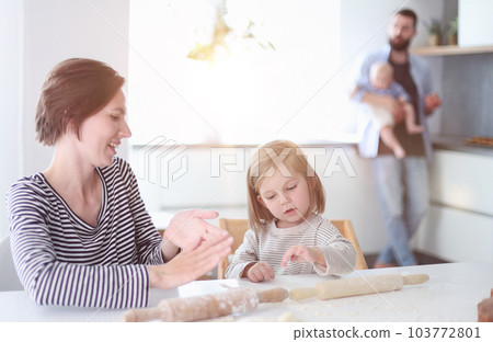 Young parents playing with children in the kitchen Young parents playing with children in the kitchen 103772801