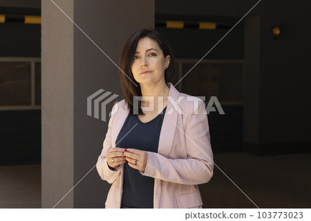 Portrait Confident Mature 40 yo Beautiful Woman, Professional Psychologist. Intelligent Caucasian Burnette Female With Brown Eyes Looks At Camera, Wears Pink Jackets, Blue Shirt. Horizontal Plane 103773023