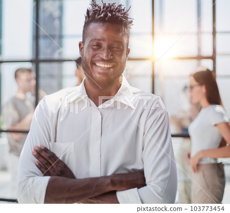 Portrait of smiling African American business man with executives working in background 103773454