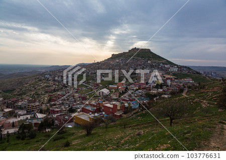 Turkey The cityscape of the old town of Mardin seen from the hill, Mardin castle standing on the mountaintop and the sunset sky 103776631