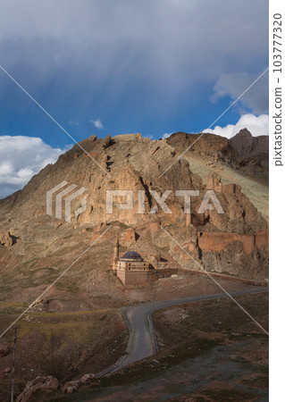 Turkey Dogubeyazit Castle built on a hillside and a rocky mountain with a cliff rising behind 103777320