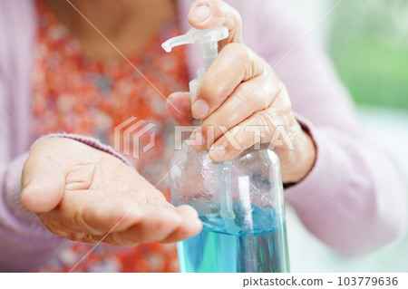 Asian senior woman press blue alcohol sanitizer gel for washing hand protect infection coronavirus. 103779636