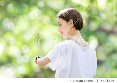 A woman operating a smartwatch, Shinryoku 103781526