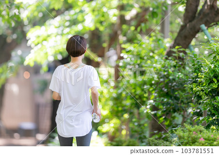 Woman jogging with water Early summer fresh green Woman jogging with water Early summer fresh green 103781551