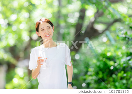 Woman jogging with water Early summer fresh green Woman jogging with water Early summer fresh green 103781555