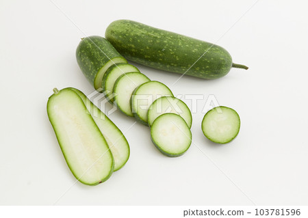 Fresh winter melon and winter melon slides displayed on a white background. Winter melon is cool and sweet so it has the effect of detoxifying, clearing heat, eliminating phlegm, and diuretic. 103781596