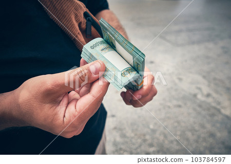 Man holds stack of Lebanese liras 103784597