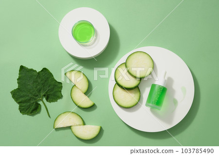 Top view of some winter melon slices and leaf with dropper bottle unbranded placed on round white podiums on a light green background. Mockup scene for advertising cosmetic of winter melon extract Top view of some winter melon slices and leaf with dropper bottle unbranded placed on round white podiums on a light green background. Mockup scene for advertising cosmetic of winter melon extract 103785490