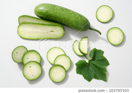 Top view, creative flat lay shot of winter melon slices and leaf decorated on white background. Parts of winter melon as: skin, flesh, seeds, leaves and flowers can all be used for food and medicine. 103785503