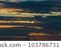 The sun's light gilds the dark storm clouds at dawn 103786731