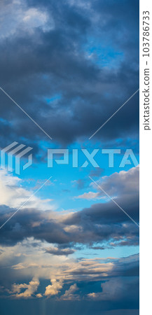 The sun's light gilds the dark storm clouds at dawn 103786733