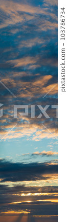 The sun's light gilds the dark storm clouds at dawn 103786734