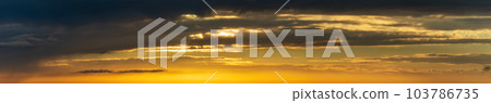 The sun's light gilds the dark storm clouds at dawn The sun's light gilds the dark storm clouds at dawn 103786735