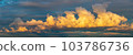 golden clouds after sunset on a dark blue sky 103786736