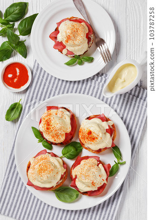 Eggs Benedict on white plate, top view 103787258