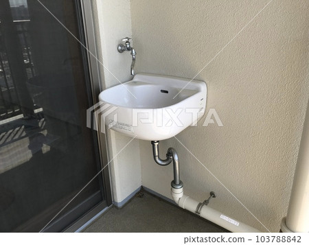 A cute slop sink installed on the balcony of an apartment building 103788842