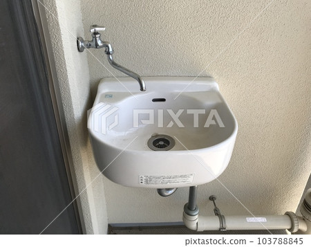 A cute slop sink installed on the balcony of an apartment building 103788845