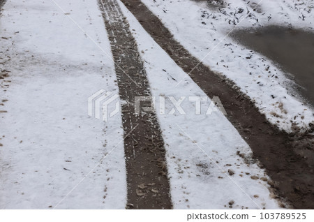 Car tracks on a snowy road. Slippery road, danger, risk of skidding. Traces of winter tire treads 103789525