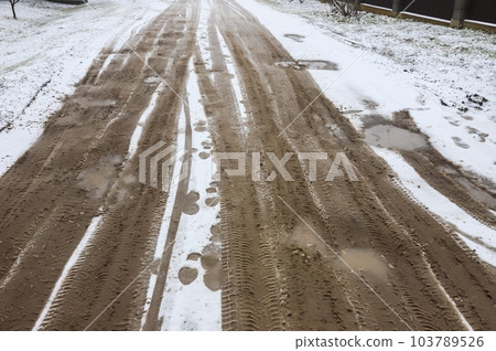 Car tracks on a snowy road. Slippery road, danger, risk of skidding. Traces of winter tire treads 103789526
