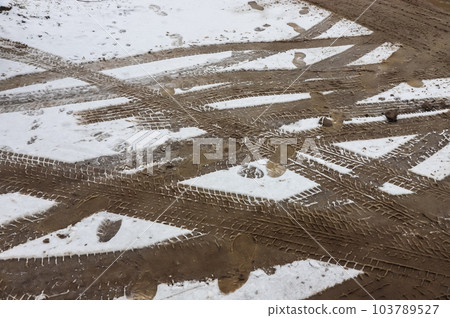 Car tracks on a snowy road. Slippery road, danger, risk of skidding. Traces of winter tire treads 103789527