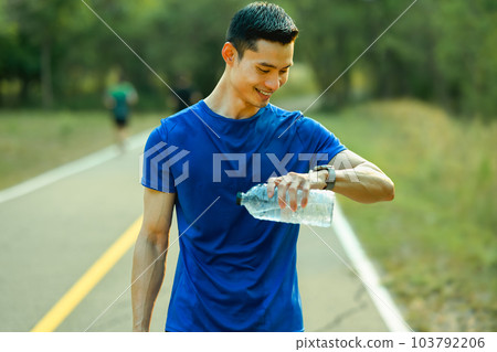 Satisfied sporty man checking pulse or training results on smartwatch. Technology health, wellness concept Satisfied sporty man checking pulse or training results on smartwatch. Technology health, wellness concept 103792206