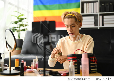 Smiling gay male beauty make up artist or blogger filming daily makeup tutorial to share on website or social media. LGBTQ, domestic life 103792616