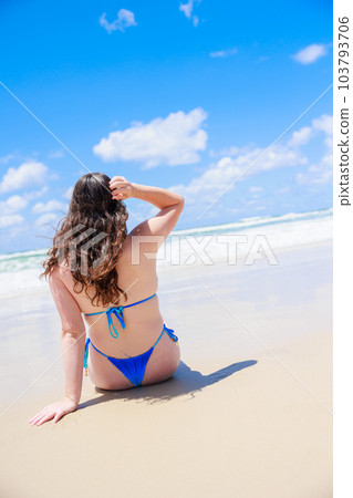 The blue sky of the sea and the back view of a sexy woman in a swimsuit (vertical photo) 103793706