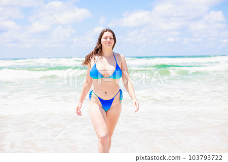 A foreign woman in a swimsuit walking from the sea A foreign woman in a swimsuit walking from the sea 103793722