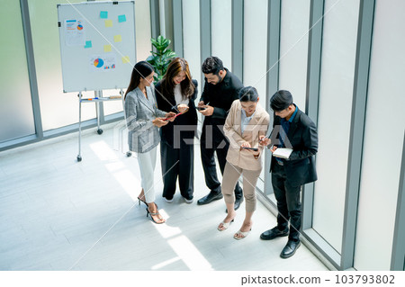 Top view of group of Asian business man and woman stand also discuss together near glass windows Top view of group of Asian business man and woman stand also discuss together near glass windows 103793802