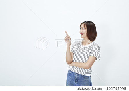 Portrait of smiling attractive asian female in casual t-shirt pointing finger upper Portrait of smiling attractive asian female in casual t-shirt pointing finger upper 103795096