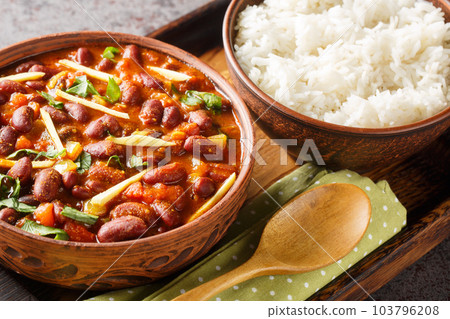 Rajma Or Razma is a popular North Indian Food, consisting of cooked red kidney beans in a thick gravy with spices served with rice close-up on a wooden tray. Horizontal Rajma Or Razma is a popular North Indian Food, consisting of cooked red kidney beans in a thick gravy with spices served with rice close-up on a wooden tray. Horizontal 103796208