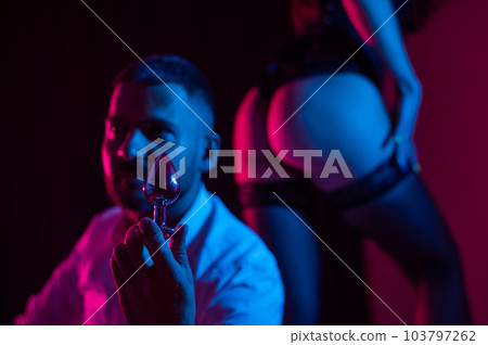 Bearded caucasian man holding an anal plug. Close-up of female buttocks in underwear. Sexual preferences of the couple. Bearded caucasian man holding an anal plug. Close-up of female buttocks in underwear. Sexual preferences of the couple. 103797262