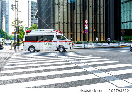 Cityscape of Tokyo, Japan An ambulance emergency running on the pedestrian crossing at the "Otemachi Ekimae" intersection. As expected safe driving = June 7 103798260