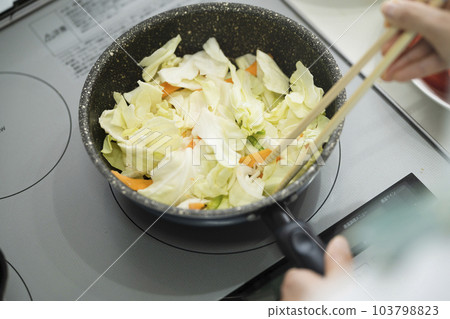 Young woman making stir-fried vegetables Cooking image 103798823
