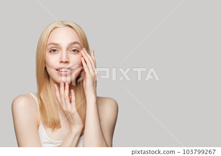 Attractive lady with healthy skin and blonde hair on grey background portrait 103799267