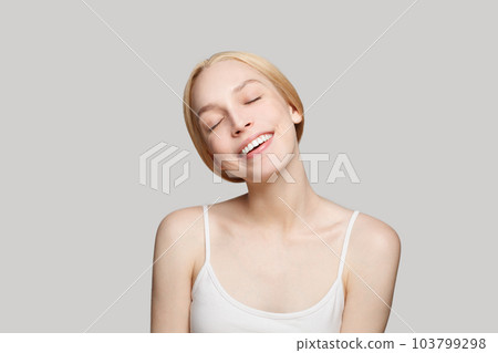 Happy blond woman with fresh shiny clear skin. Facial treatment, skincare and cosmetology concept Happy blond woman with fresh shiny clear skin. Facial treatment, skincare and cosmetology concept 103799298