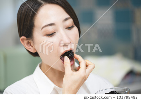 Young woman eating prune Food and drink image 103799482