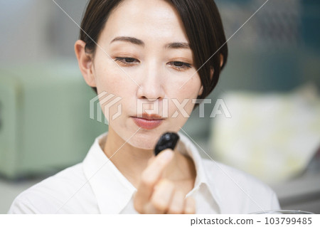 Young woman eating prune Food and drink image Young woman eating prune Food and drink image 103799485