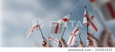 A group of people holding small flags of the Northern Ireland in their hands A group of people holding small flags of the Northern Ireland in their hands 103801414