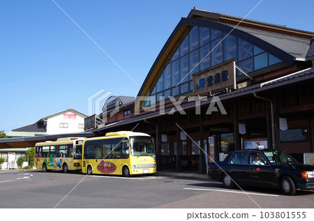 A scene of a yellow wide-area life bus arriving and stopping at the bus stop at JR Yasugi Station 103801555