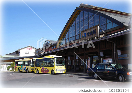 A scene of a yellow wide-area life bus arriving and stopping at the bus stop at JR Yasugi Station (illustration style) 103801594