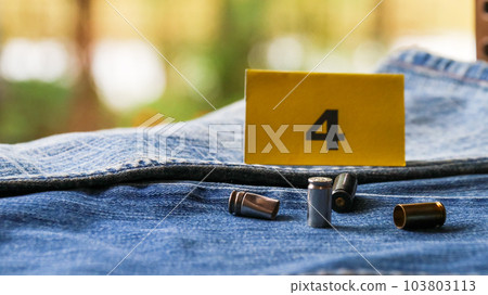 Pistol bullet shells on blur blue jeans and number four display in background, concept for criminal and investigation. soft focus 103803113