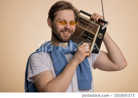 Happy man using retro tape record player to listen music disco dancing of favorite track having fun 103805373