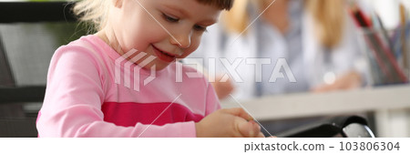 Little girl child makes injection to toy in doctor office 103806304