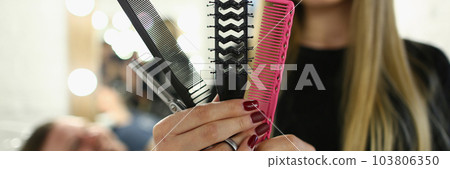 Woman hairdresser holding set of combs and scissors in a barbershop 103806350